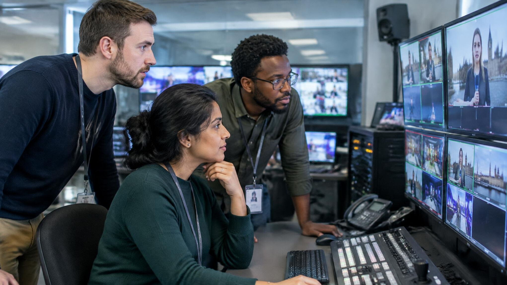 Production team reviewing footage on a monitor in a control room